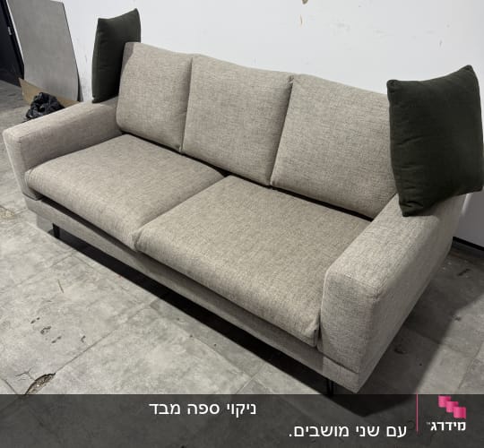 ספה אפורה על רצפת בטון בחדר ריק